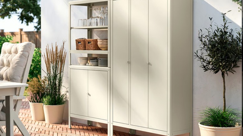 IKEA KOLBJÖRN Verandada raf ünitesi, raflarda bitki malzemeleri ve içecek takımları.