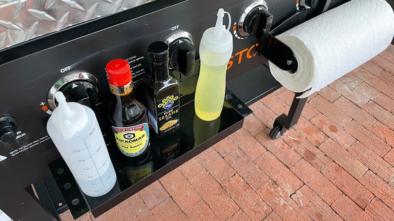 Harbor Freight'ten siyah manyetik bir tepsi, yağlar ve soya sosuyla kaplı bir ızgaraya tutturulmuştur.