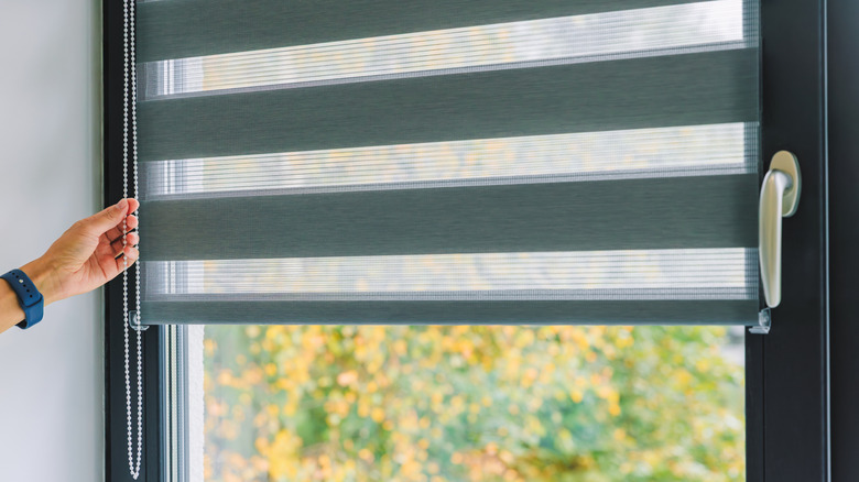 Pencere kör kablosunu çeken kişinin yakın çekimi