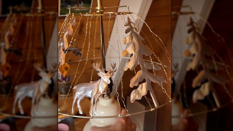 Bakır tel kıvrımları ve pop kutularından kesilmiş ormanlık şekillerle yapılmış bir DIY abajur