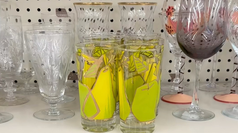 Yeşil ve sarı armutlar ve elmalardan oluşan altı adet Fred Press Highball bardağı seti, ikinci el bir mağazanın rafında duruyor.