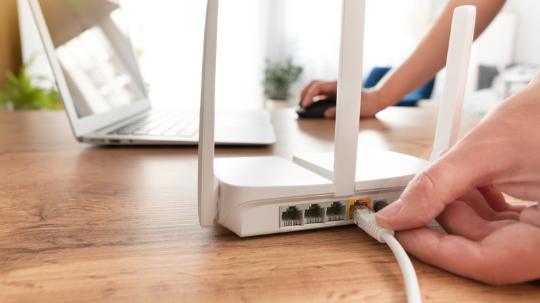 Masasına Wi-Fi yönlendirici bağlayan kişi