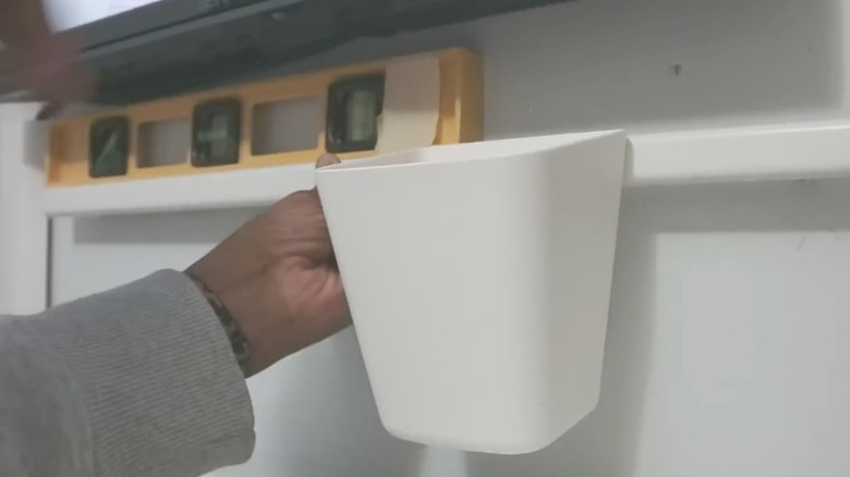 IKEA SUNNERSTA'nın kurulumu için duvarı işaretlemek için seviye kullanan kadın