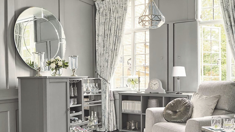 Aşırı tasarlanmış lüks bir oturma odasında uyumlu çiçekli perdeli, çiçekli bir Laura Ashley Türk halısı.