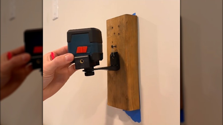 El DIY lazer seviye montajını duvara karşı tutar