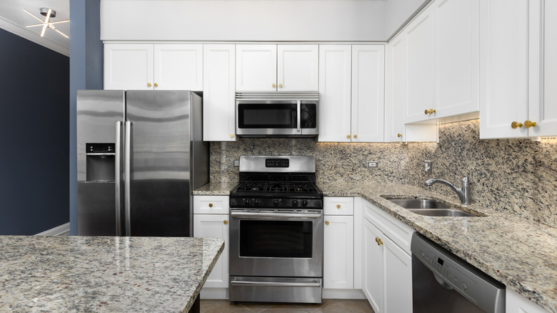 Gri granit backsplash'lı bir mutfak
