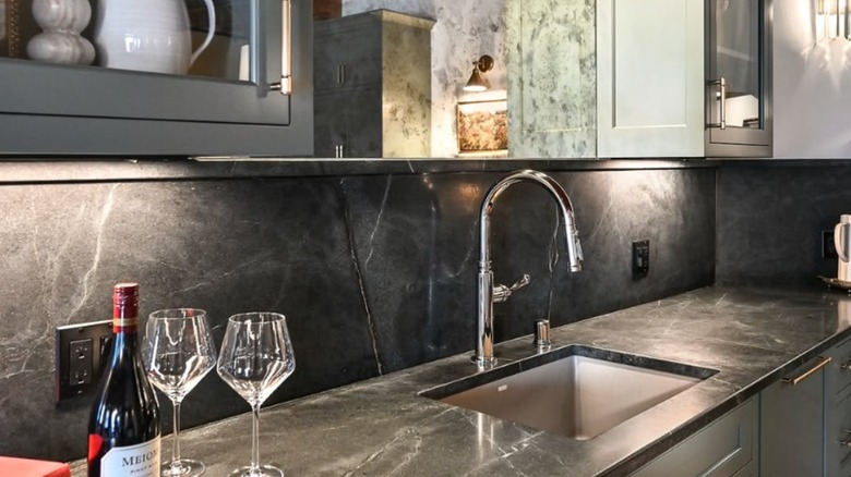 Tezgahın üzerinde iki kadeh şarap bulunan sabuntaşı bir backsplash