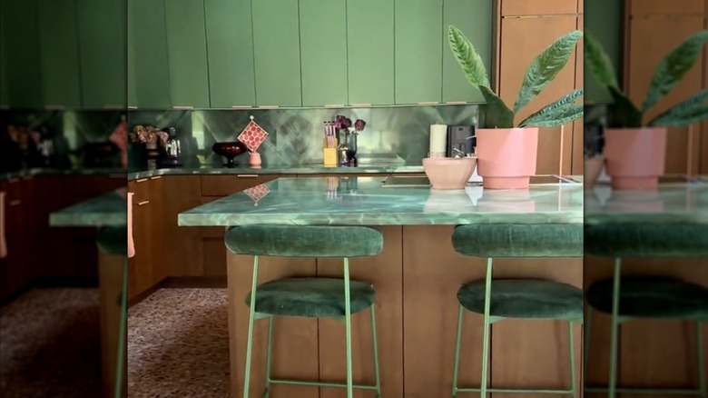 Yeşil zümrüt backsplash ve kahverengi dolaplara sahip bir mutfak