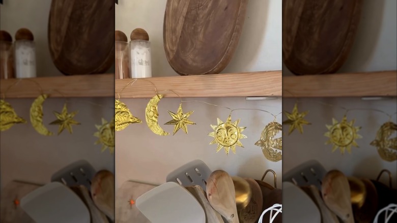 Altın kabartmalı metal yıldızlar, güneşler ve aylardan oluşan çelenk