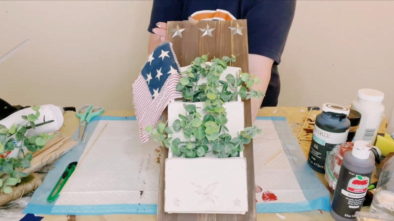 Okaliptüs yaprakları ve Amerikan bayrağıyla dolu el işi masasının üzerinde duvara monte posta tutucusu