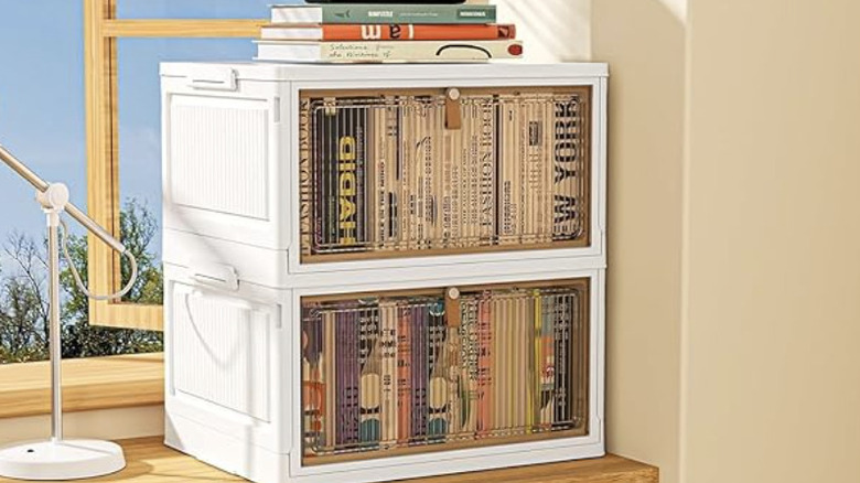 Masanın üzerinde kitapların saklandığı, iki kademeli 4 katlı tekerlekli düzenleme kutusunun ürün resmi.