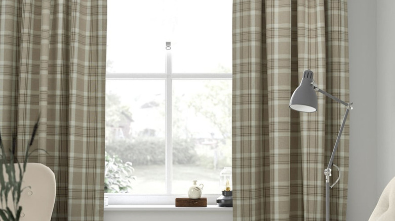 Okuma ışığı bulunan aydınlık bir odada HÄGGVECKMAL perdeler