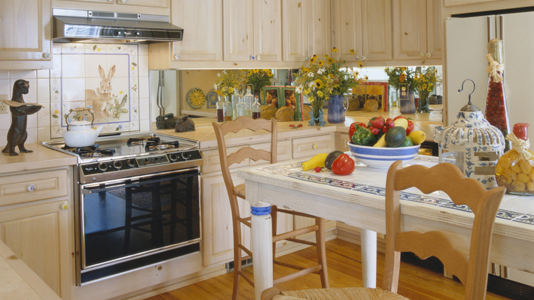 Dekor uyumsuzluğu, vintage bir su ısıtıcısı ve bir sürü çiçek içeren sıcak ve eklektik bir mutfak.