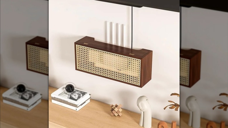 HJAGDJ'nin konsolun üzerindeki duvara monte edilmiş rattan yönlendirici saklama kutusu