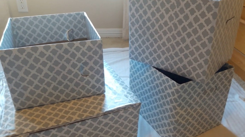 Ahşap damarlı temas kağıdıyla kaplı ve turkuaz ve beyaz desenli temas kağıdıyla kaplı bir karton kutu