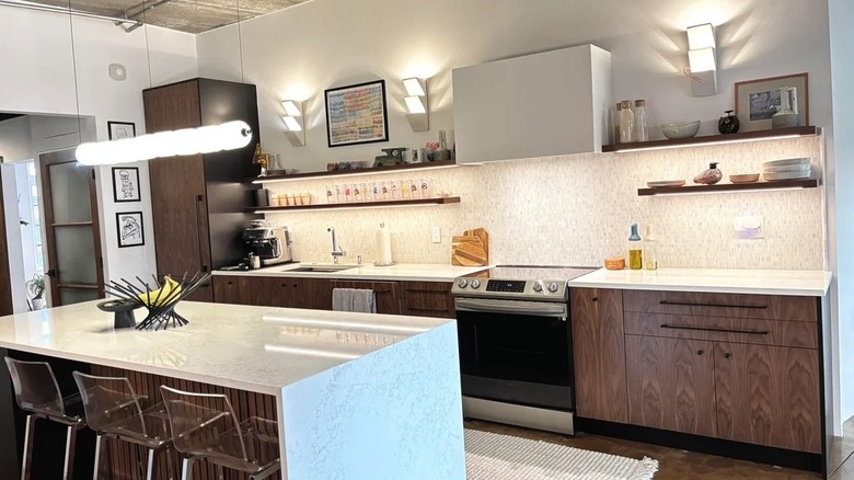 Karanlık dolaplar ve mutfak adası bulunan endüstriyel tarzda çatı katı dairesi