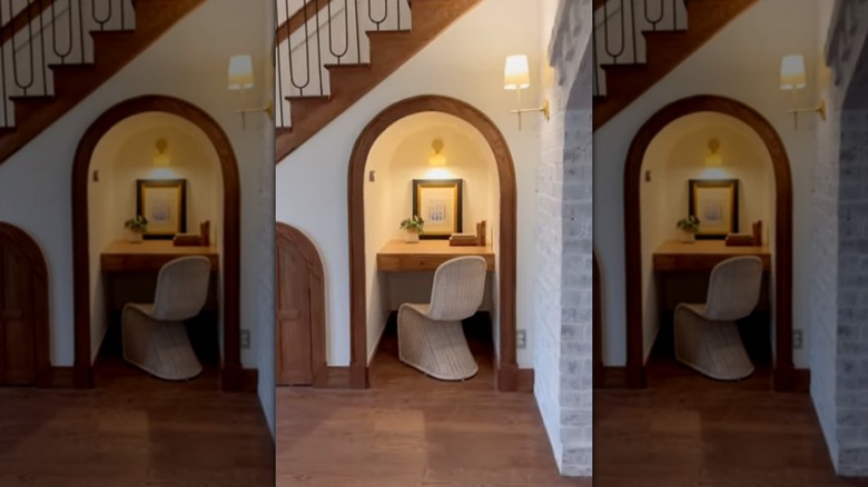 Merdivenlerin altında küçük bir masanın bulunduğu ofis köşesi