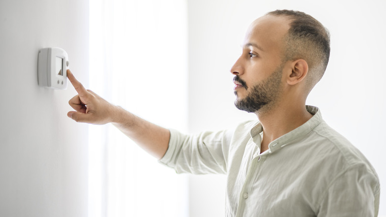 Adam termostatı ayarlıyor