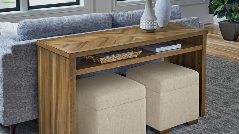 Oturma odasındaki mavi-gri kanepenin arkasındaki Universal Broadmoore Zelanda Kanepe Masası