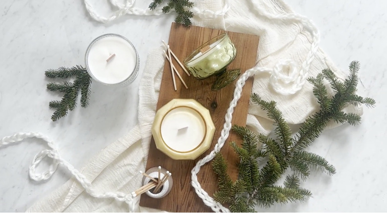 Vintage esintili ısıya dayanıklı kavanozlarda yapılmış mumlar süslü bir masanın üzerinde duruyor.