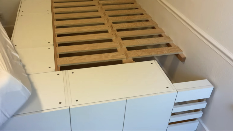 Depolama ve ahşap çıtalara sahip bir yatak çerçevesi.