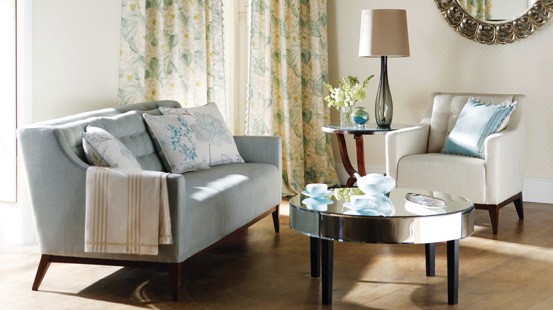 Açık mavi ve beyaz ev dekorasyonuna sahip oturma odası