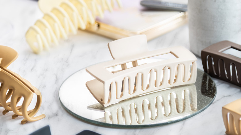 Ayna ve diğer eşyaların bulunduğu masanın üzerine farklı saç pençe klipsleri dağılmıştı.