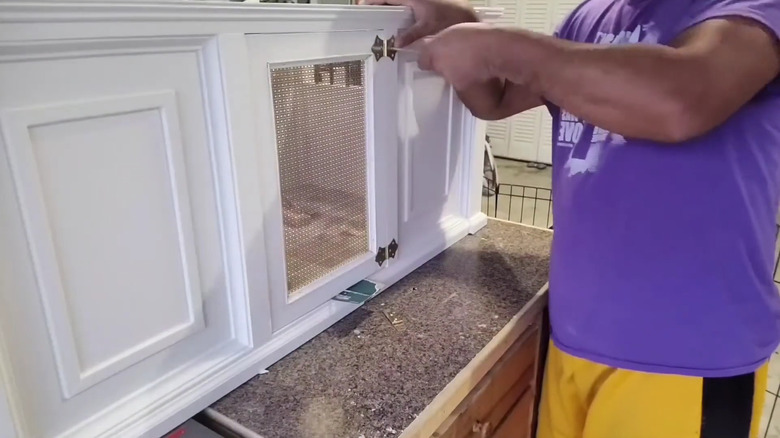 Bir adam küçük köpeği için bank ve sandık kombinasyonuna son rötuşları yapıyor