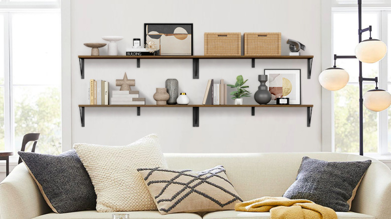 Büyük beyaz bir kanepenin arkasında yüzen kitap rafları.