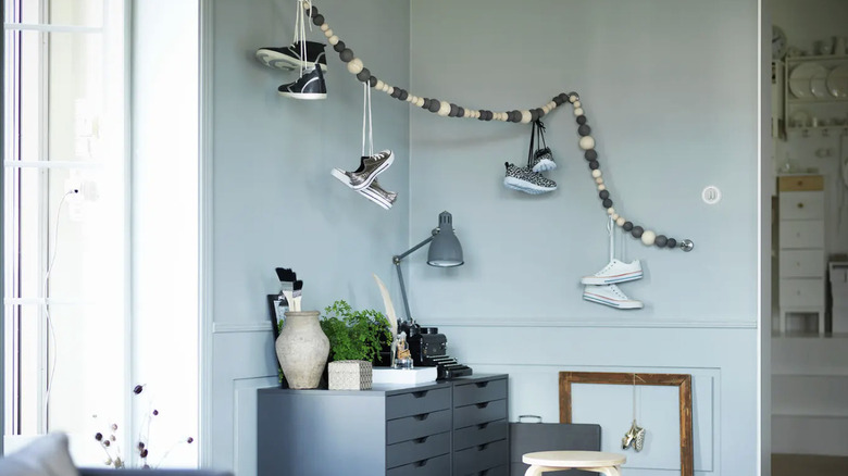 Tahta topları olan bir telden bağcıklarından sarkan spor ayakkabılar.