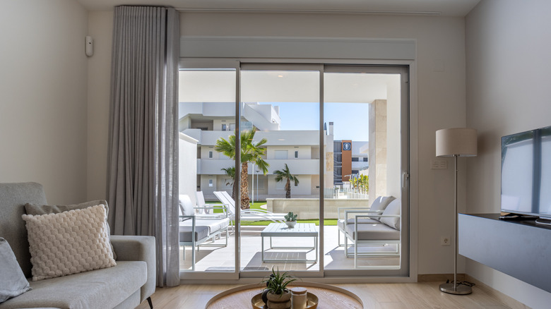 Arka bahçedeki ışığı ortaya çıkaran açık gölgeli sürgülü cam kapılar