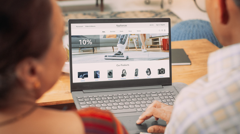 Bir çift internetten ev aletleri satın almak için dizüstü bilgisayar kullanıyor