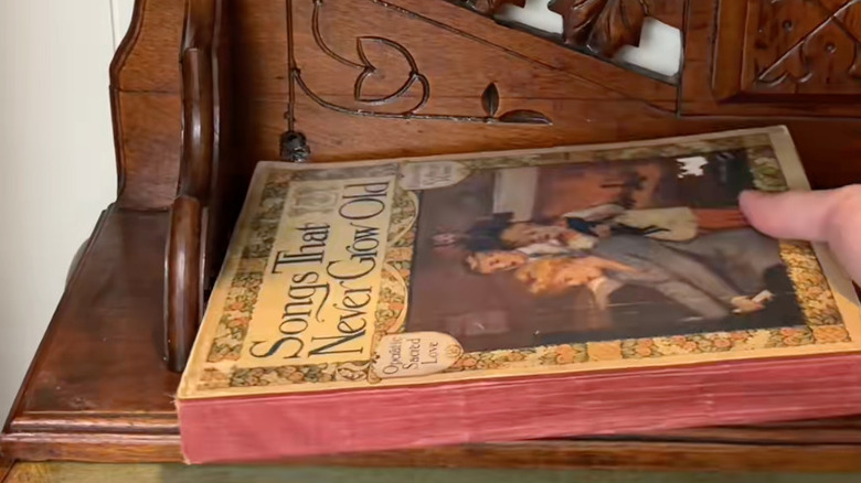Masanın üzerinde ters çevrilmiş ve kitap depolamak için kullanılan eski bir dekoratif ahşap duvar rafı.