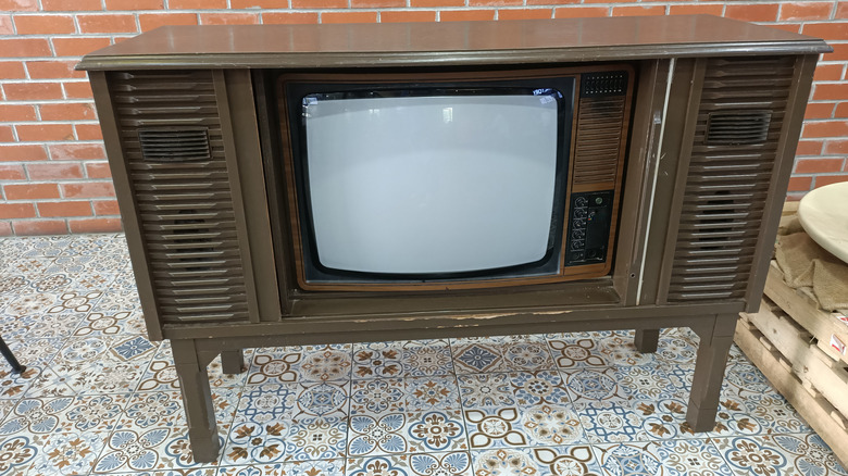 Tuğla duvarın önünde retro konsol televizyon