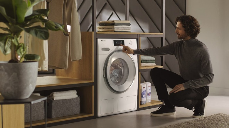 Miele çamaşır makinesi kullanan adam