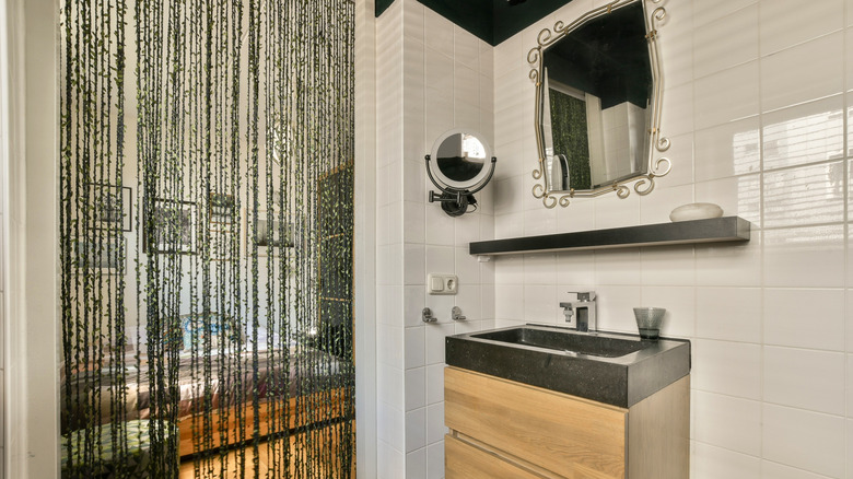 Altında çam dolaplı bir lavabo ve üstünde yüzer bir raf. Ayrıca duvara tutturulmuş büyük bir ayna ve uzatılabilir kol üzerinde büyütücü bir ayna bulunmaktadır. Kapıya alternatif olarak krem ​​rengi fayanslar ve rafya asılıdır.