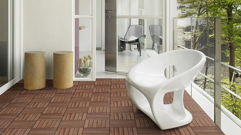 Modern veranda mobilyaları ve arka planda bir orman bulunan geniş bir balkonda Yaheetech güverte döşemeleri.