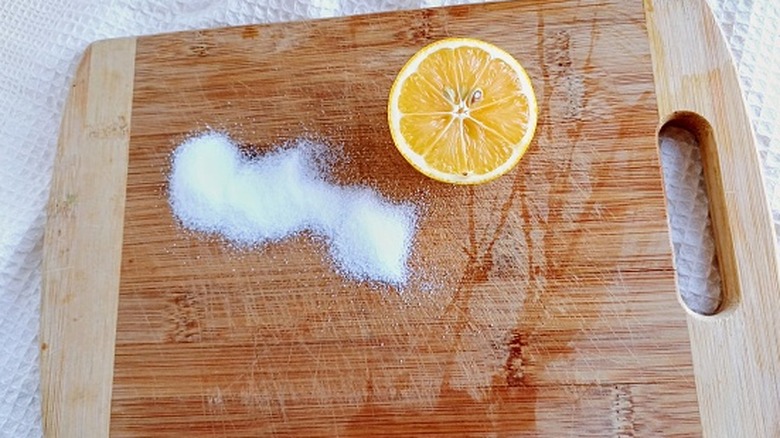 Ahşap kesme tahtası üzerinde tuz ve yarım limonun yakın plan görüntüsü