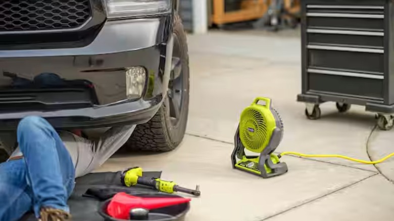Ryobi taşınabilir fan ve Bluetooth hoparlör, arabası üzerinde çalışırken adamı rahat ettiriyor