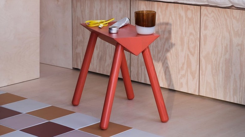 IKEA standı, sıcak tonlarda dekora sahip bir odada vazo ve diğer nesneleri tutar.