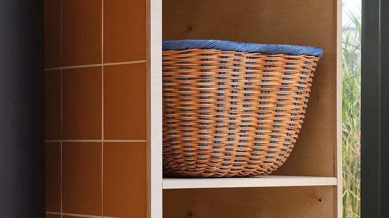 IKEA'nın rattan sepeti açık bir dolaptaki rafta duruyor.