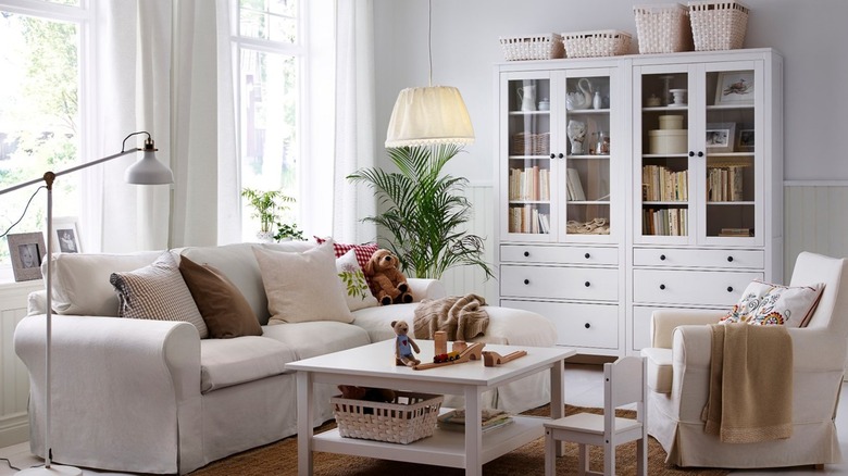 Oturma odasında iki beyaz HEMNES Cam kapılı dolap