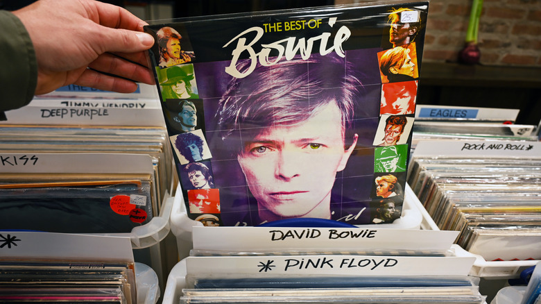 Yığından David Bowie albümünü çıkaran bir adamın elinin yakın çekimi