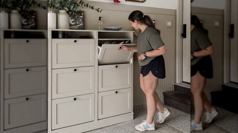 Bir kadın IKEA BRUSALI ayakkabı dolaplarından yapılmış büyük bir depolama sisteminin çekmecesini açıyor.
