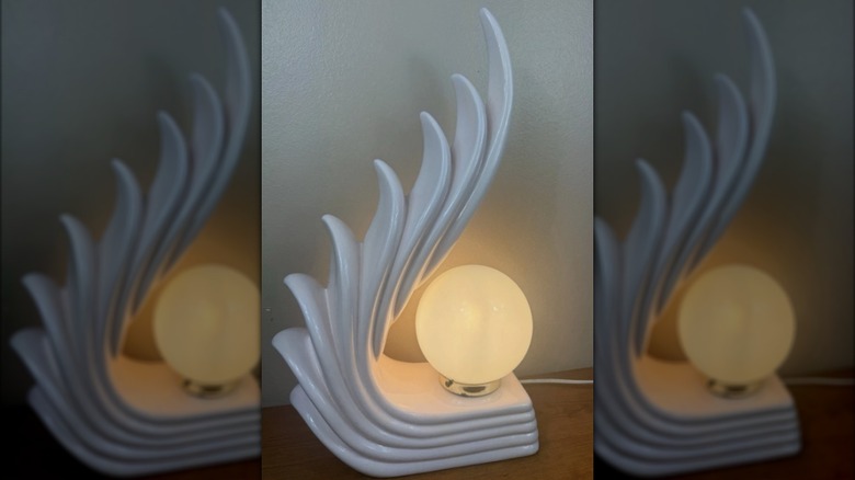 Beyaz bir Art Deco basamaklı kanat lambası yanıyor.
