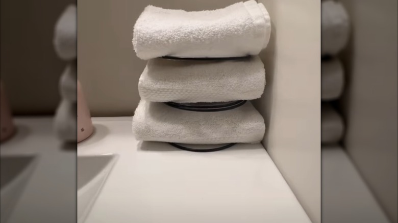 Peçete tutuculardan yapılan kendin yap küçük banyo havlusu saklama çözümü, küvetin kenarında durur.