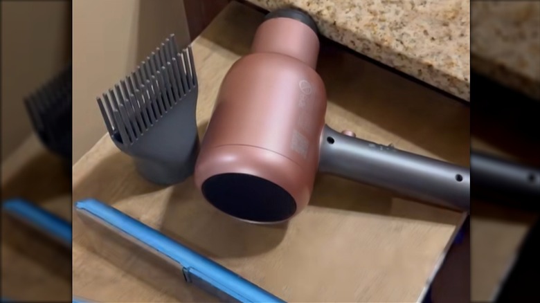 Bir saç kurutma makinesi ve düzleştirici, açık bir çekmece için DIY ahşap bir üst kısımda bulunur.