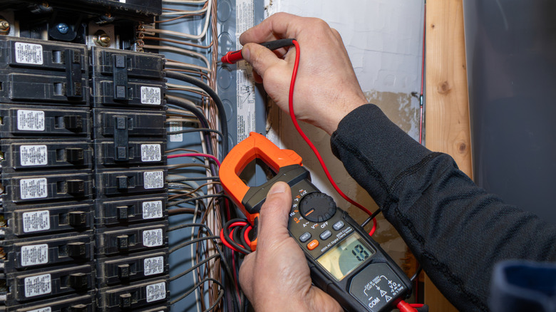Bir elektrikçi devre kesicileri kontrol ediyor