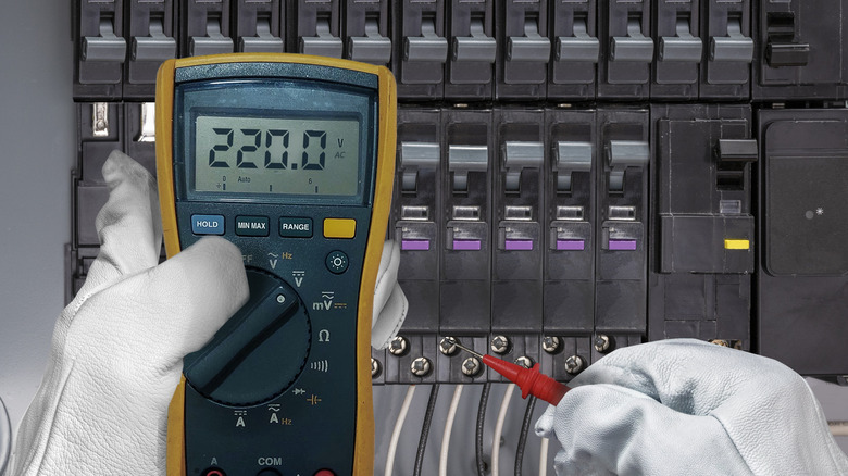 Bir elektrikçi devre kesici panelini test ediyor