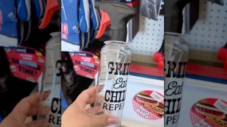 Bir el, üzerinde ölçüm işaretlerinin ve üzerinde Grill Eat Chill Repeat yazısının yazılı olduğu bir sprey şişesini tutuyor.